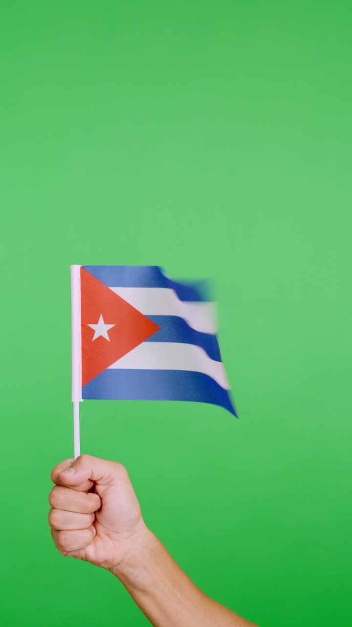 Mano che solleva un gagliardetto cubano che sventola al vento