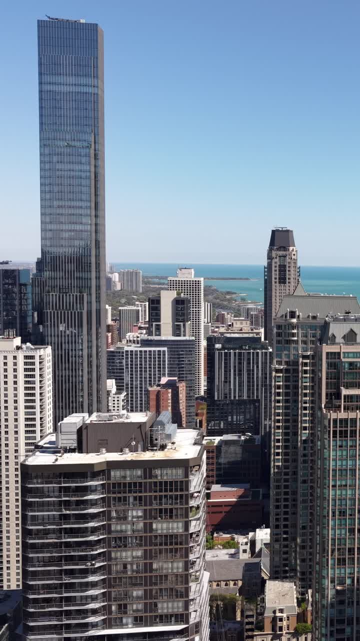 Filmagem vertical com drone do centro de Chicago, EUA, torres à beira do lago e edifícios em um dia ensolarado, Illinois, EUA