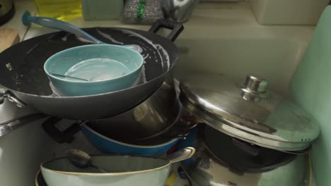 kitchen sink over-flowing with dishes to be washed