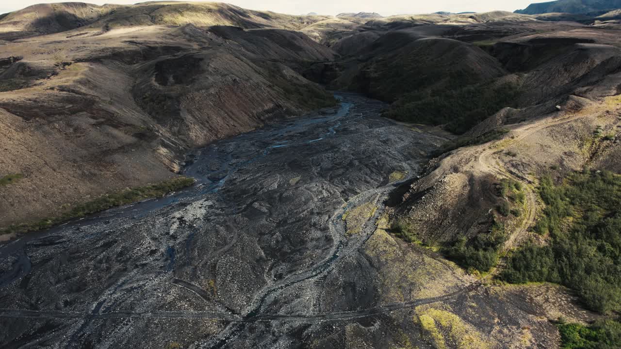 Aerial thorsm&ouml;rk glacial riverbed in mountain ranges, flying over famous icelandic national park landmark landscape