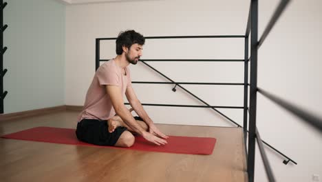 hombre estirándose en casa en el tapete de yoga