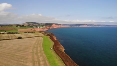 aerial over farmland countryside landscape beside english channel in devon