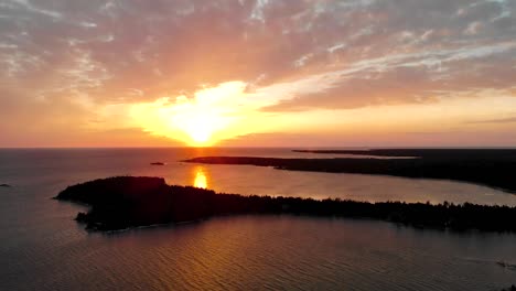 Toma-Aérea-Sobre-El-Gran-Lago-Y-La-Península-Durante-La-Puesta-De-Sol-Dorada-Con-Nubes