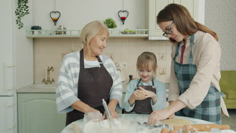 grandmother, mother and granddaughter baking cookies