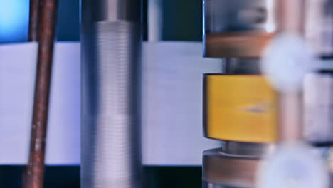 diaper producing factory. shiny metal roller spinning around. blurred shaft at the backdrop. close up.