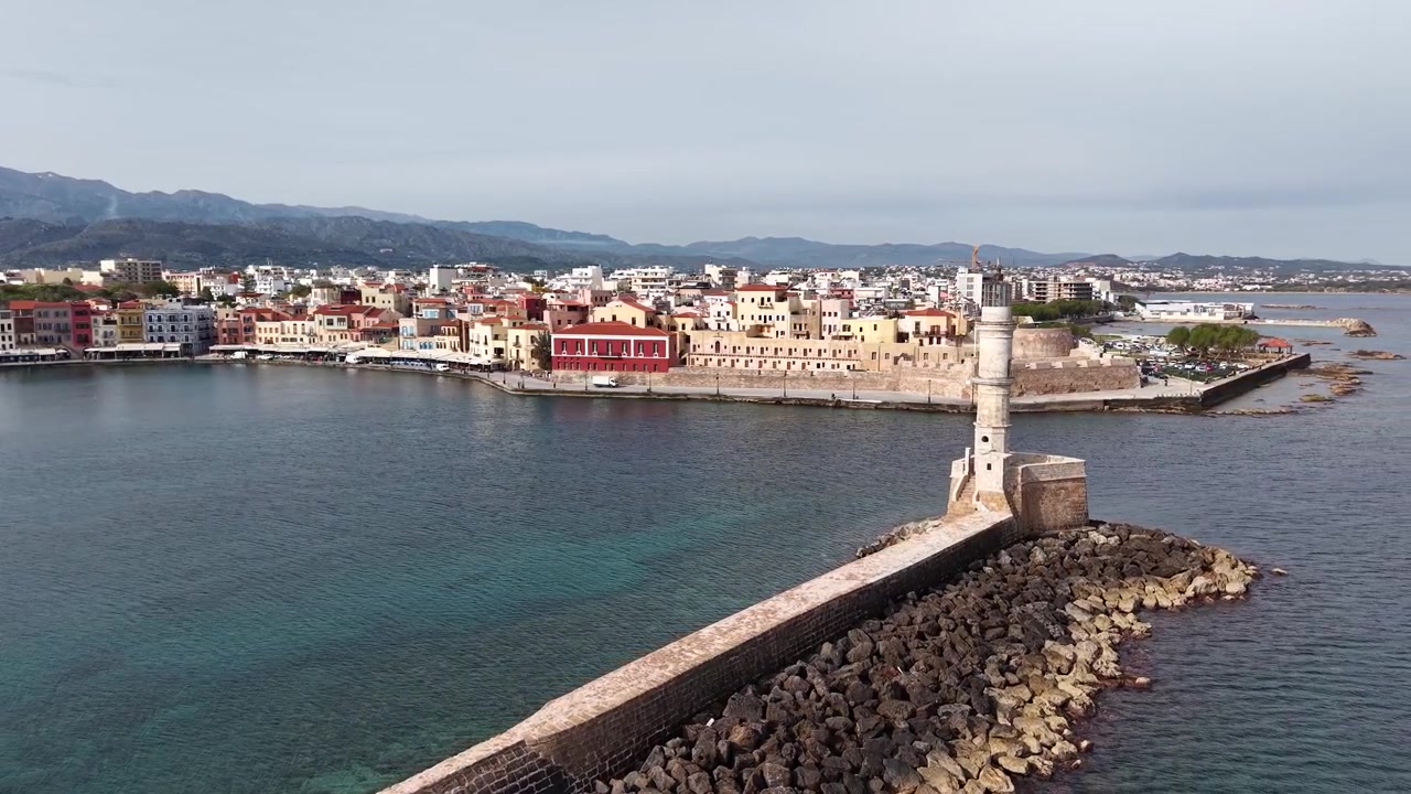 Riprese aeree cinematografiche con drone che mostrano lo storico Faro Veneziano e il porto di Chania.