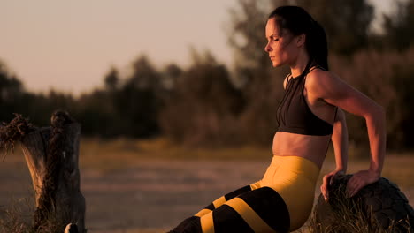 Push-ups-or-press-ups-exercise-by-young-woman.-Girl-working-out-on-grass-crossfit-strength-training-in-the-glow-of-the-morning-sun-against-a-white-sky-with-copyspace.