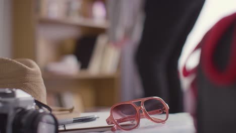 person packing suitcase for summer holiday with sunglasses and hat in foreground 1