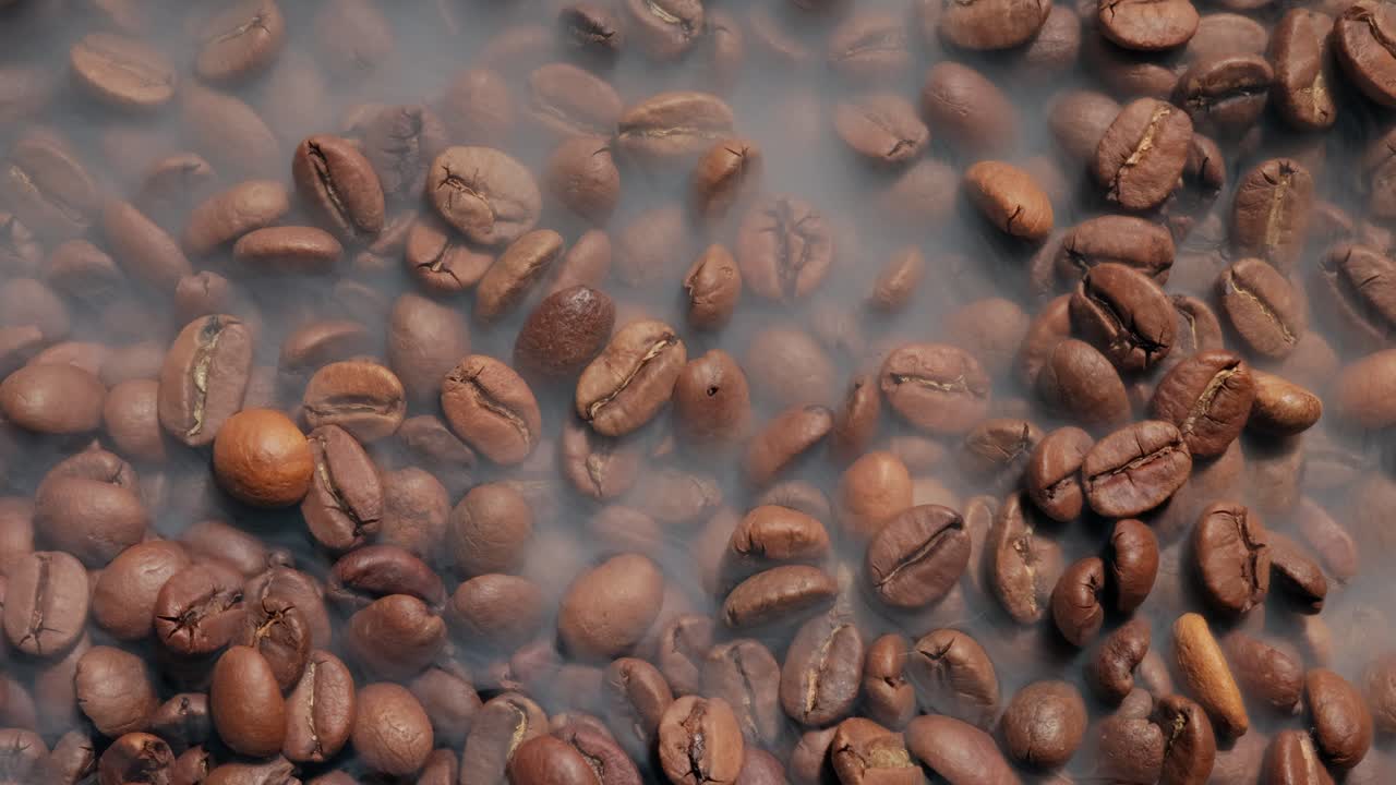 cerca de las semillas de café. los granos de café perfumados son tostados el humo viene de los granos de café.