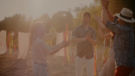 cheerful young women and men dancing with arms raised