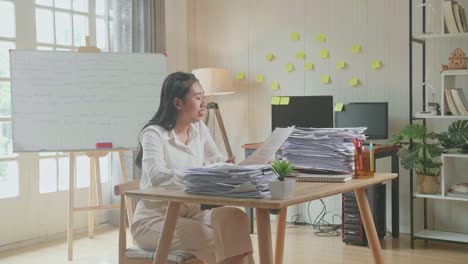 happy asian woman celebrating finishing working with documents at the office