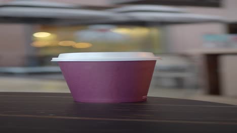 a paper cup of coffee on a table in a cafe