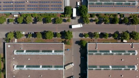 Aerial-birds-eye-overhead-top-down-view-of-trucks-cars-manoeuvring-in-an-industrial-site.-Industry,-logistic-and-transportation-concept.-Berlin,-Germany