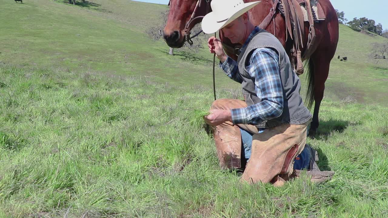Com um dolly para um plano geral, o cowboy verifica a qualidade de sua grama.