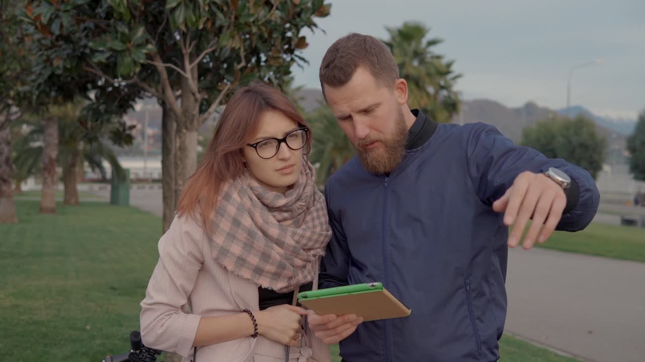 pareja usando una tableta en un parque