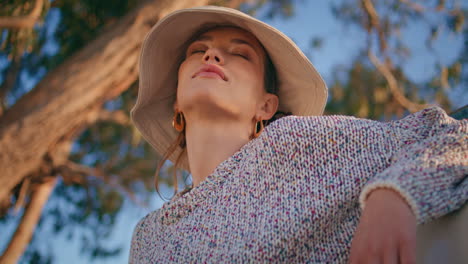 serene woman closing eyes in sunlight closeup. calm beautiful model in garden