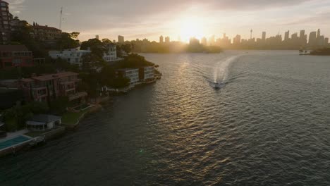 sunset over sydney's point piper, with luxurious homes and a boat on the water