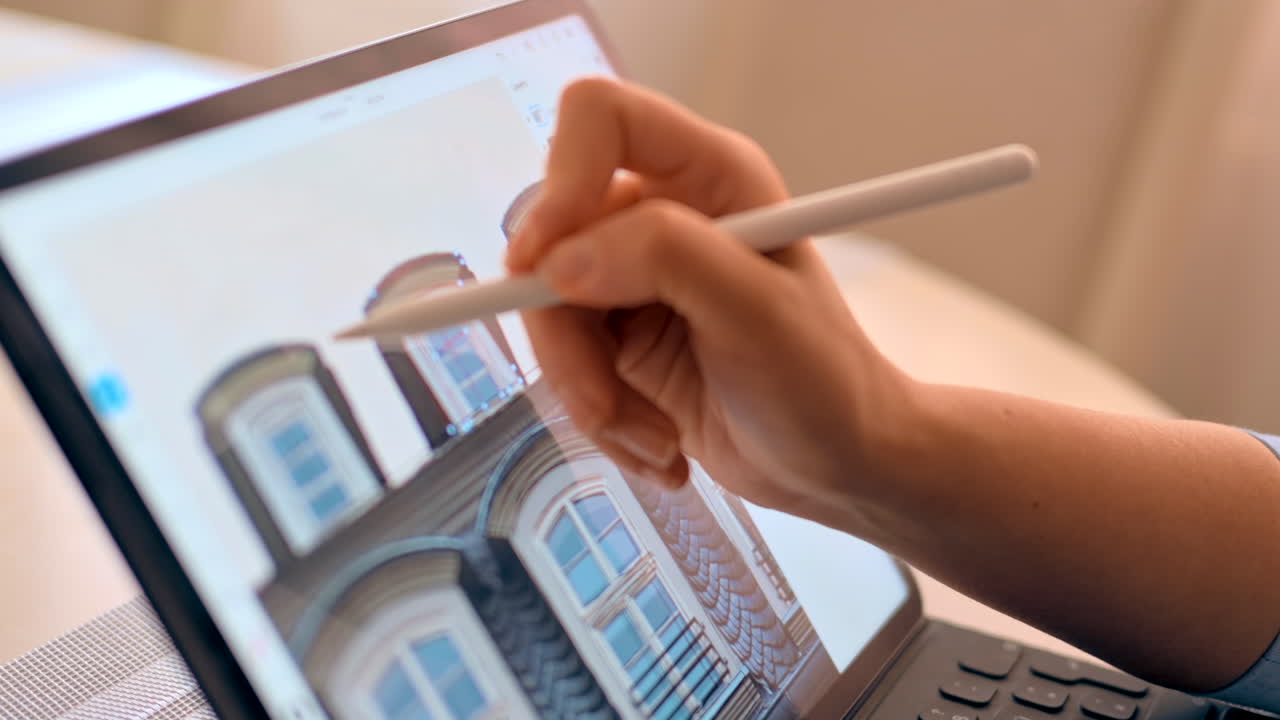 Woman drawing a building on a tablet with a stylus pen