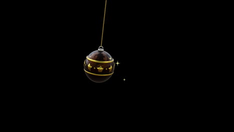 swinging black and gold christmas bauble and gold sparkles on black background