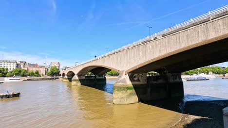 a boat travels under a bridge in london