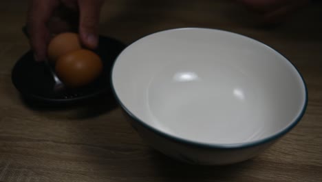 empty bowl and an egg is broken, scrambling eggs in a bowl