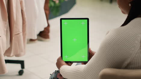 cliente de la tienda con tableta de pantalla verde