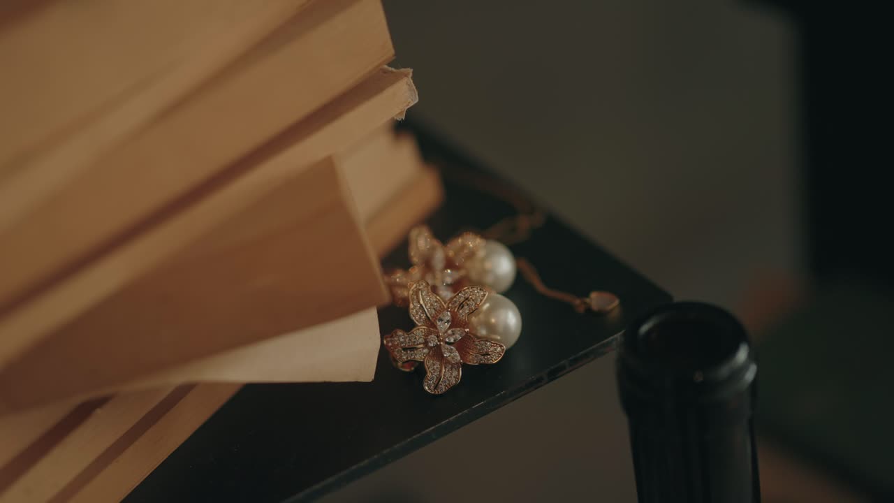 Primo piano di orecchini di perle posizionati accanto a libri impilati