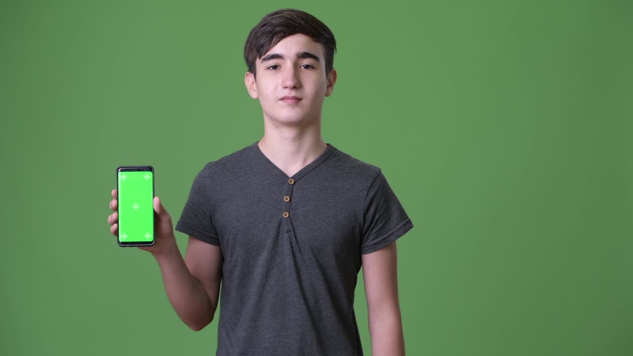 초록색 배경에 젊은 잘생긴 이란 십대 소년