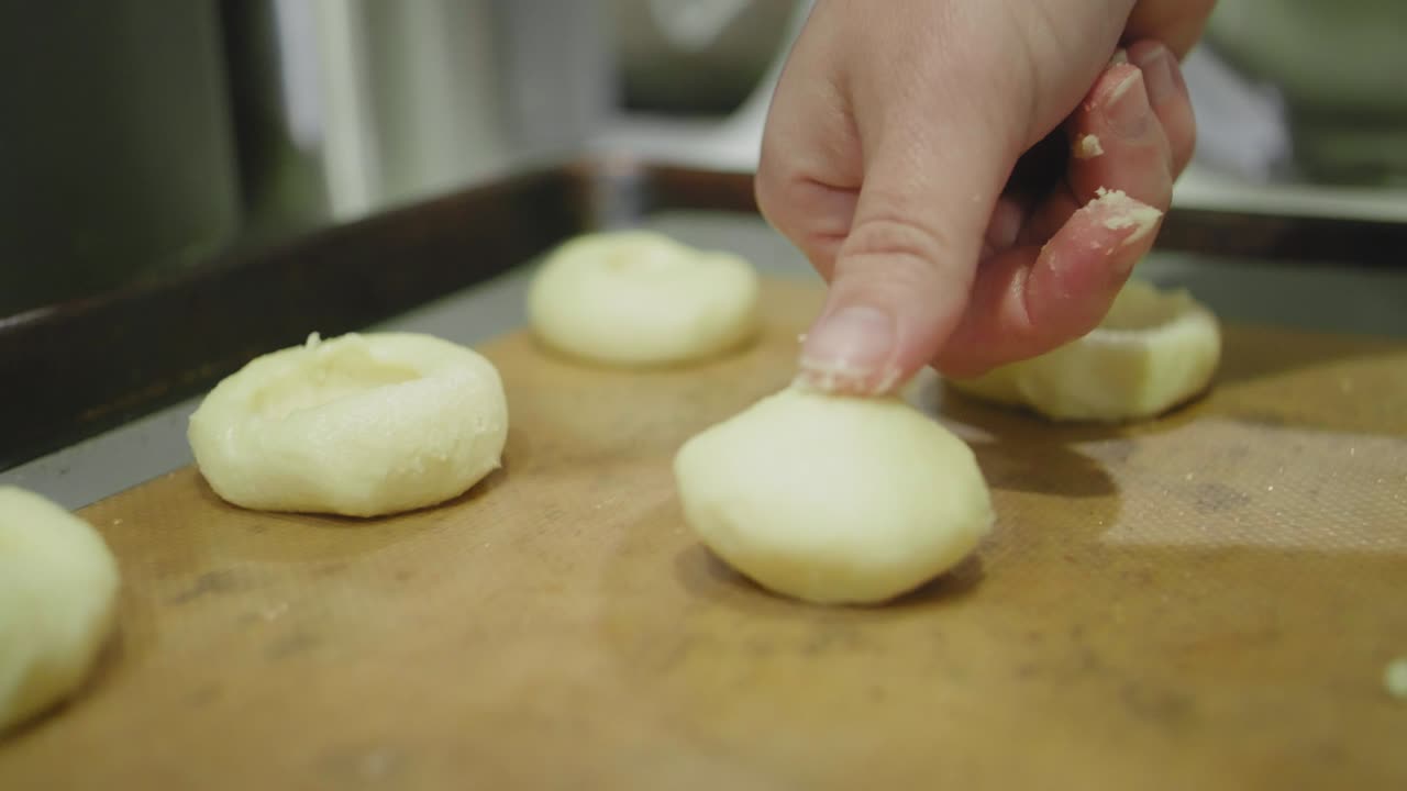 Pressing an Indentation into Sugar Cookies to Make Room for Jam