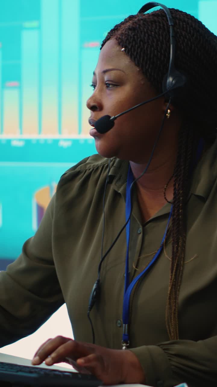 Profesjonell afroamerikansk kvinne som snakker i headset i et callsenter