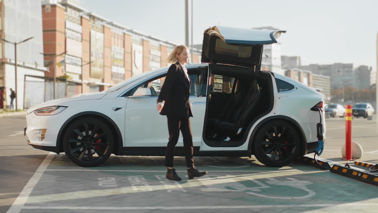 주차장 에서 전기 차량 을 떠나는 여자