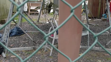 silla de jardín bajo el casco del barco proyecto de reparación de astillero vallado seguro pasando timón dolly izquierda