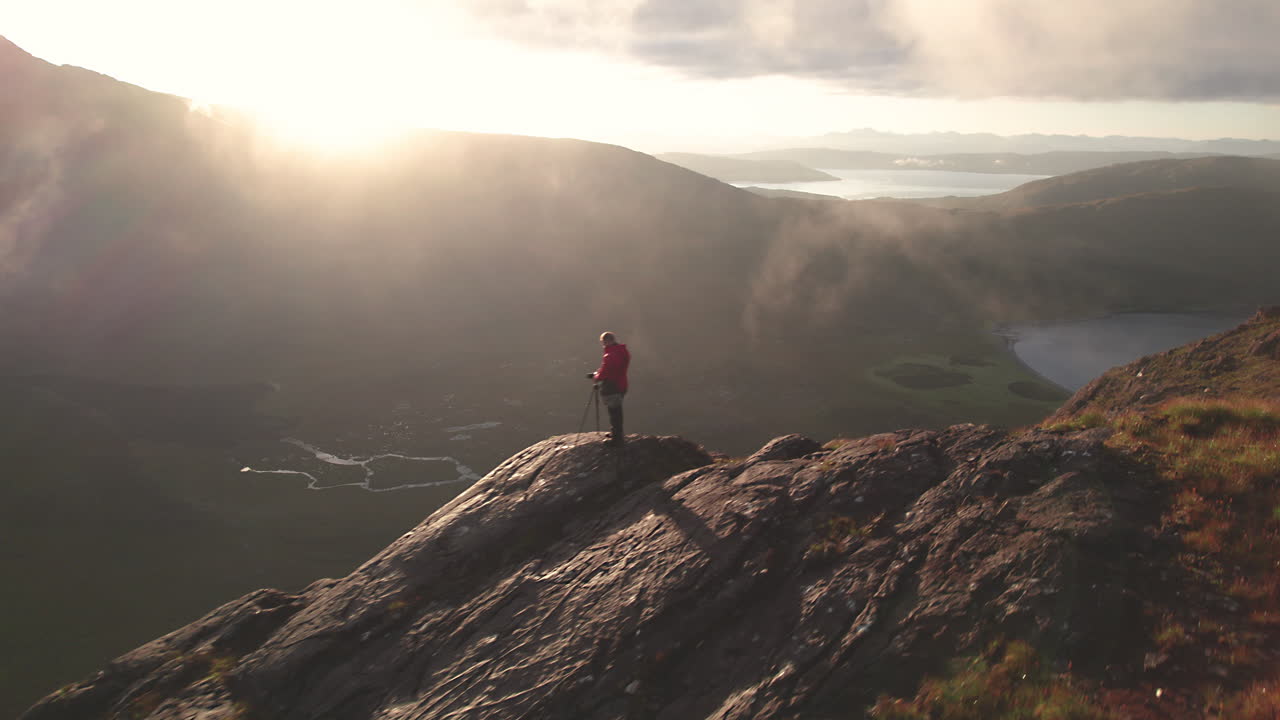 volando cerca de un fotógrafo, que está capturando la hermosa vista montañosa en las tierras altas escocesas