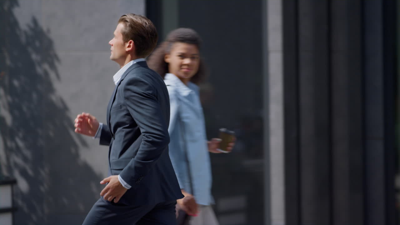 trabajador financiero serio corriendo rápido para una reunión de trabajo en el patio de la oficina gris moderna.