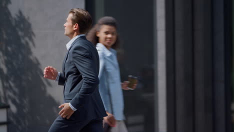 serious finance worker running fast for work meeting in modern gray office yard.