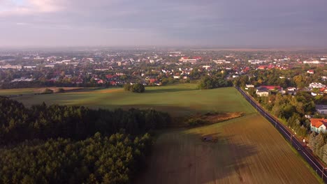 flying from right to left over the suburban landscape and adjacent field and copse