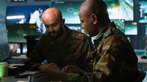 army officers doing brainstorming in command center, looking at intel