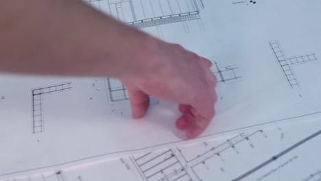 person examining architectural blueprints