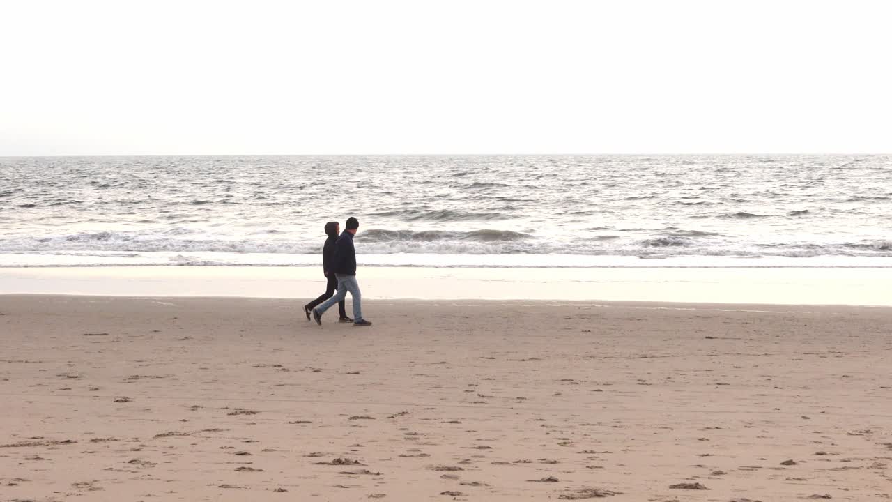 People walking at the beach on a chilli cloudy afternoon in California Venice beach