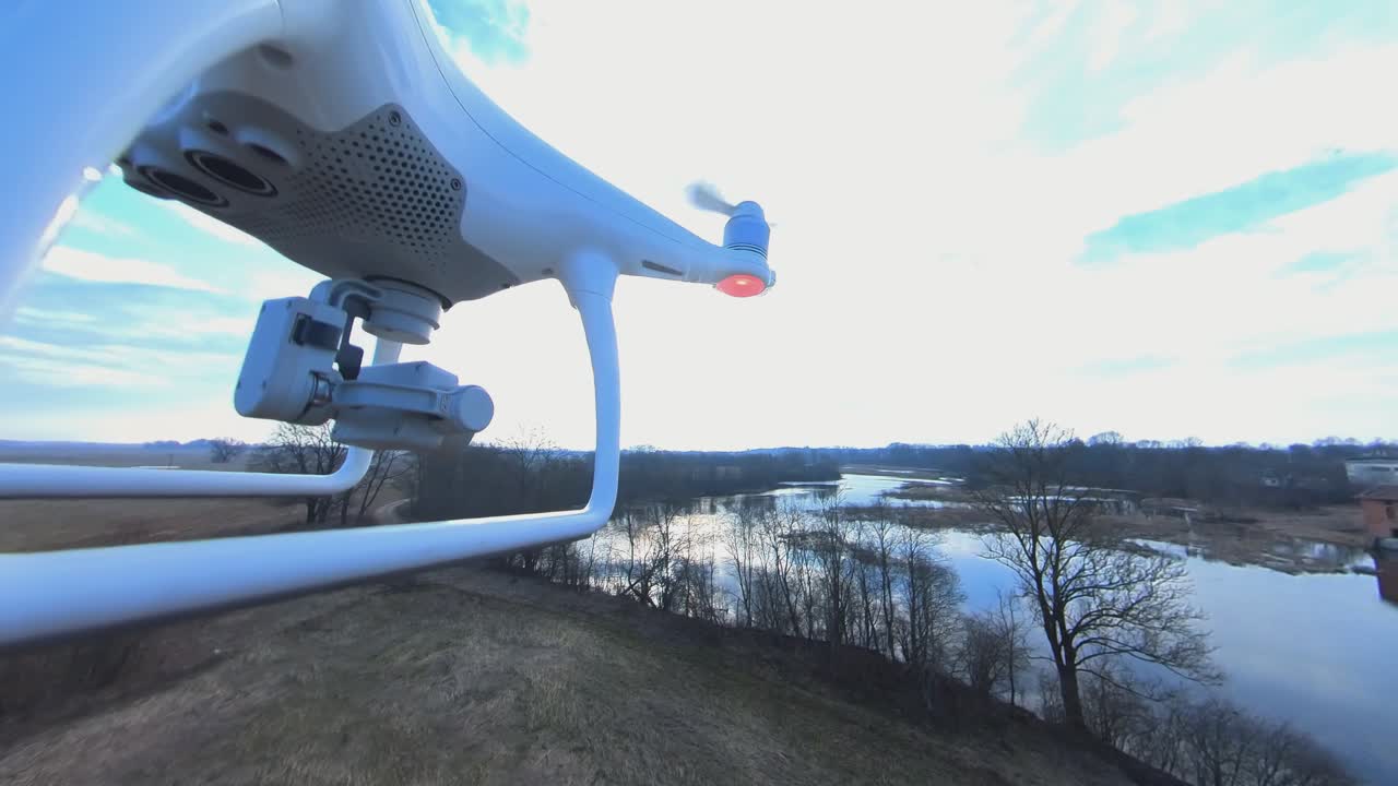 구불구불한 강을 향해 앞으로 날아가는 dji 팬텀 4 쿼드콥터 드론의 클로즈업 측면 보기