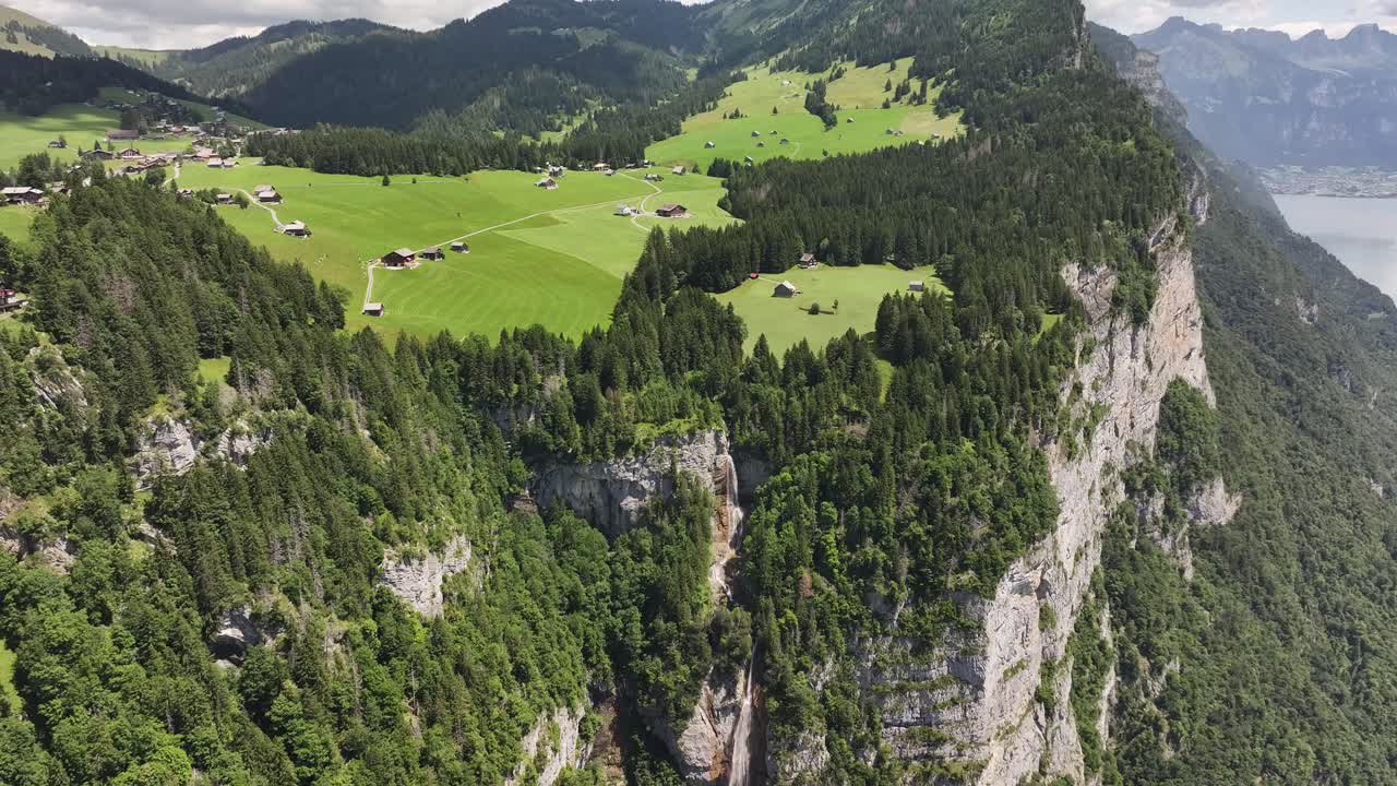 Aerial view of Betlis village perched above Seerenbachfälle waterfall on the cliffs by Walensee, Switzerland