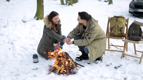 Caucasian-couple-camping-in-a-snowed-forest.