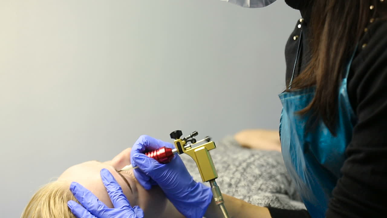 Tattooist using tattoo pen machine for eyebrows permanent make up