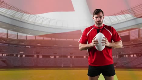 professional rugby player standing in front of a flag and stadium