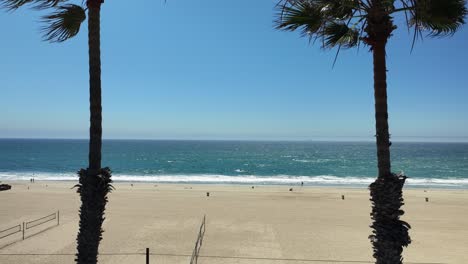 Vista-Creciente-De-Palmeras-Y-Redes-De-Cancha-De-Voleibol-En-Huntington-Beach-En-El-Sur-De-California-Mirando-El-Océano-Pacífico