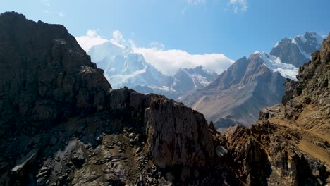 cinematic aerial forward shot rises above a rugged huayhuash peak, unveiling a massive mountain range and expansive valley in the wild peruvian andes