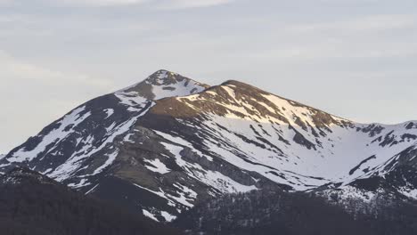 mountain ridge with trees under cloudy sky