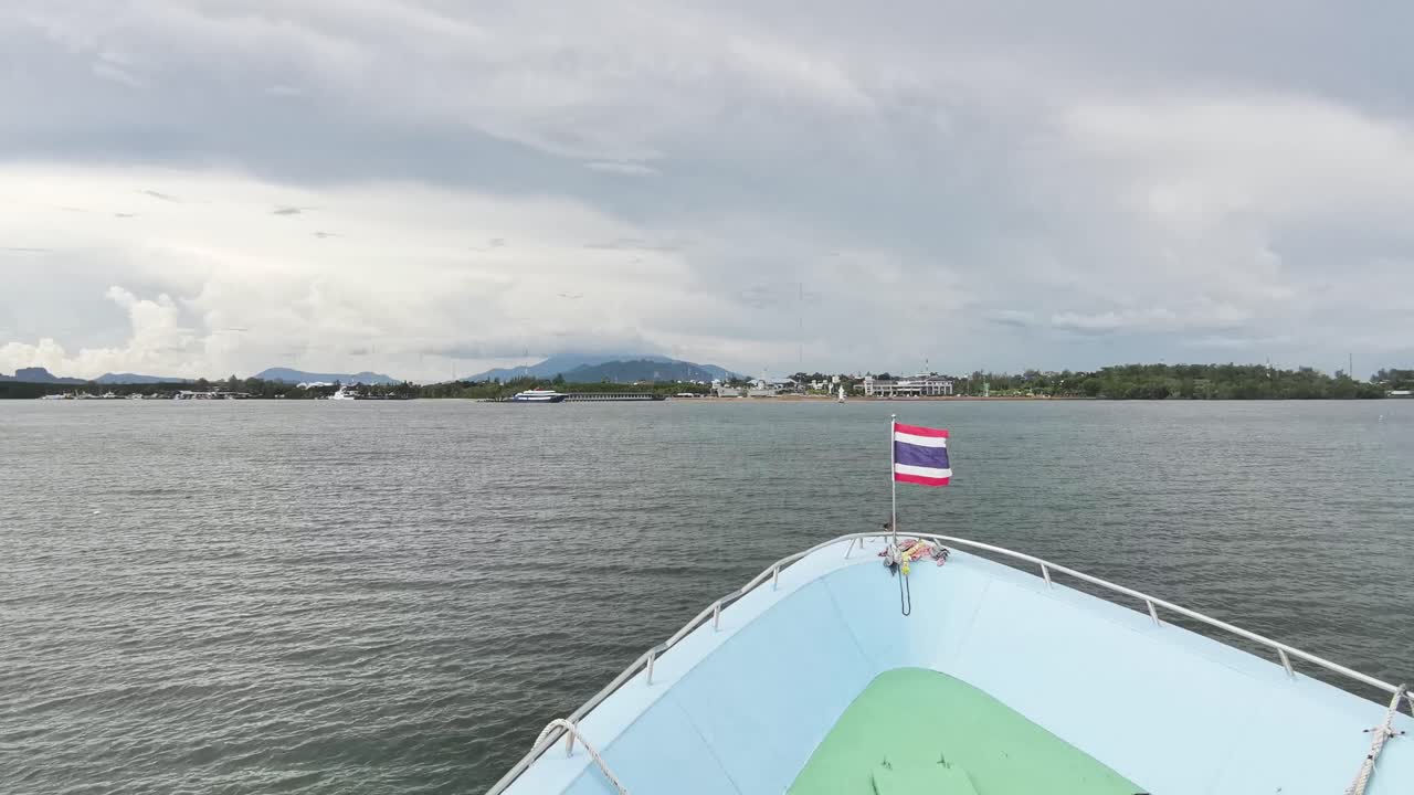 Thai Ferry Arrival from Koh Phi Phi Islands with Flag Fluttering in the Wind, Showcasing Scenic Ocean Vista and Thailand's Breathtaking Landscape
