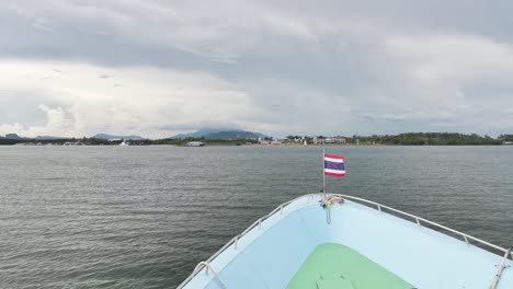 la llegada del ferry tailandés desde las islas koh phi phi con la bandera ondeando en el viento, mostrando la vista panorámica del océano y el impresionante paisaje de tailandia