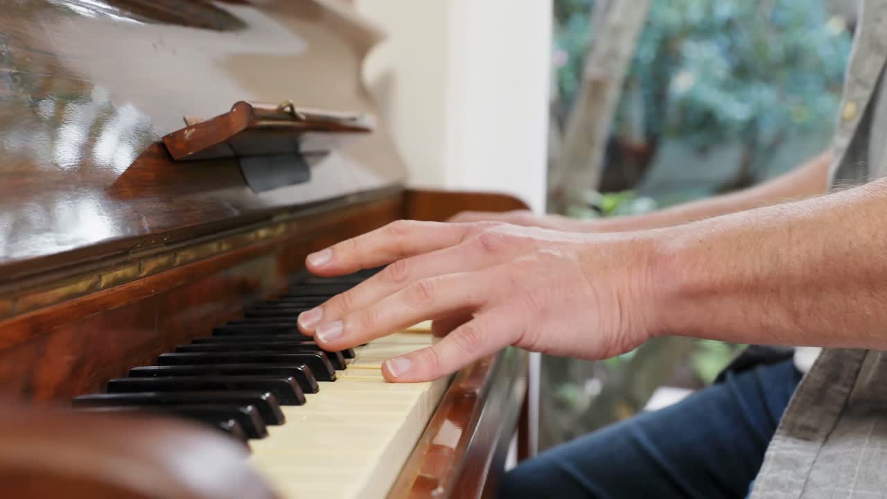 hombre tocando el piano en la sala de estar en casa 4k